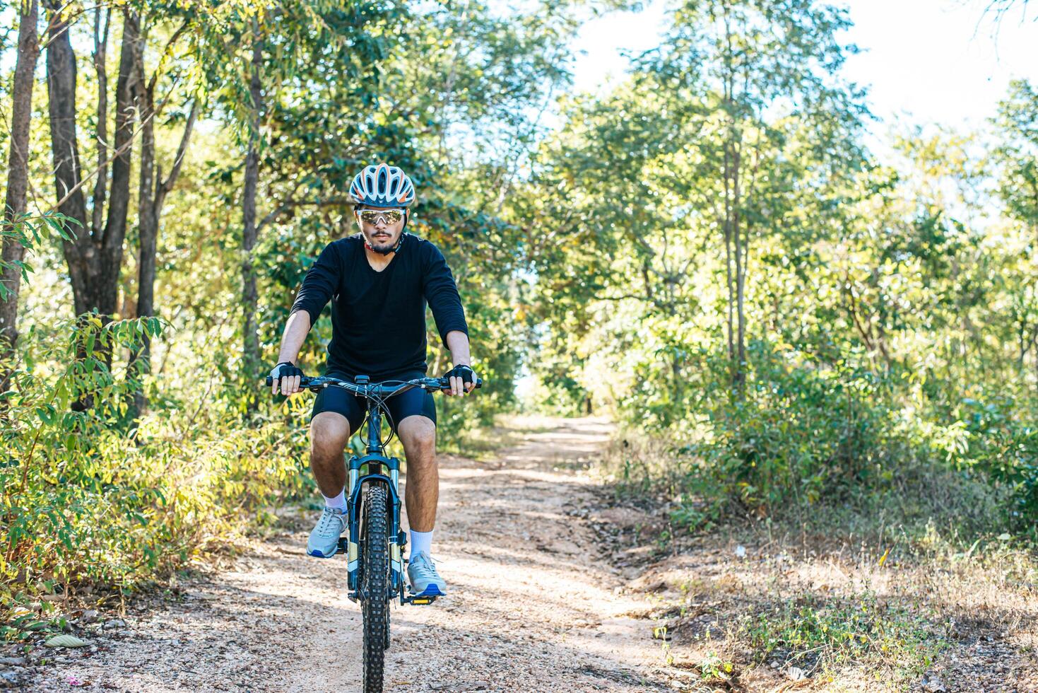 der Mann, der auf einem Bergpfad Fahrrad fährt a foto