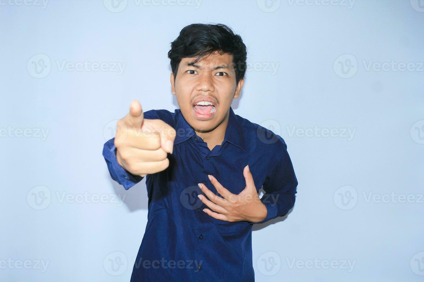 frustriert asiatisch jung Geschäftsmann mit wütend Gesicht ist zeigen Finger und suchen zu Kamera tun Schuld Sie Geste zum Konkurs foto