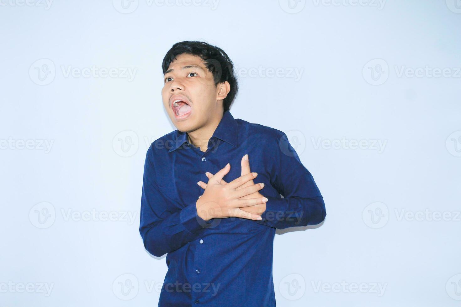 asiatisch Mann Büro Arbeiter schreiend und berühren seine Truhe Leiden von Herz Attacke Schmerzen tragen Marine Shirt, isoliert Weiß foto