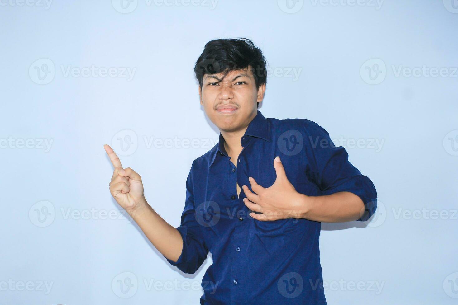dankbar asiatisch Geschäftsmann ist lächelnd nach Leiden von Herz Attacke Show präsentieren Geste mit zeigen Finger zu Seite foto