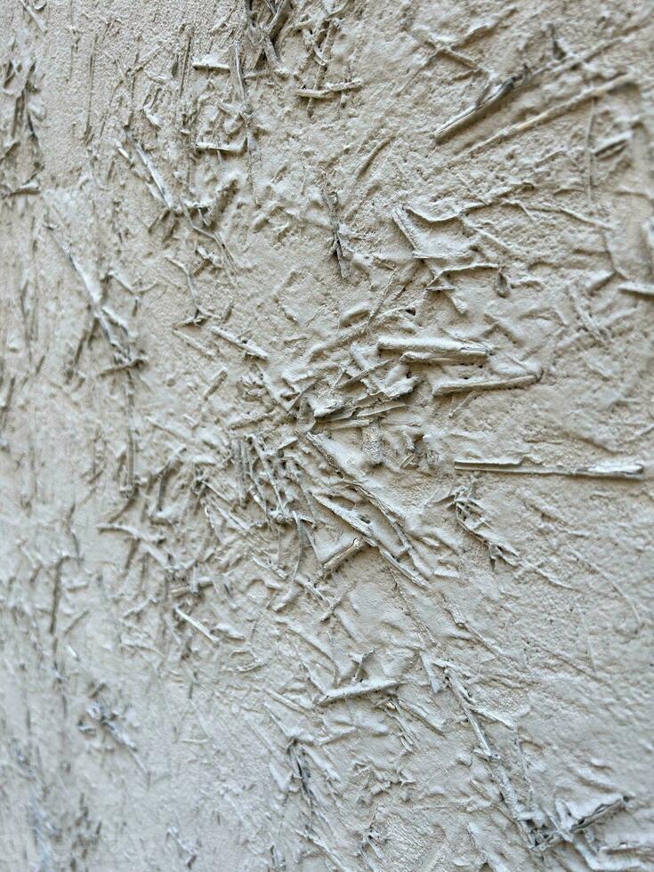 texturiert Hintergrund. Mauer gemalt mit Weiß malen. Weiß Mauer ist gemalt mit Heu und Reis Stroh. abstrakt Hintergrund mit alt Weiß Gips. grau Farbe Hintergrund. Vertikale Komposition foto