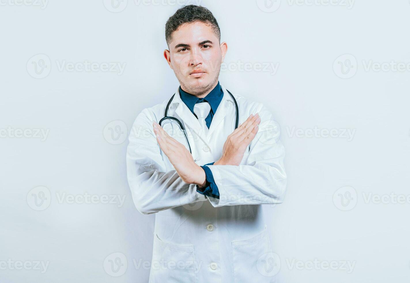 Arzt Kreuzung Hände im Verweigerung Geste isoliert. jung Arzt Herstellung halt Zeichen mit Hände isoliert foto