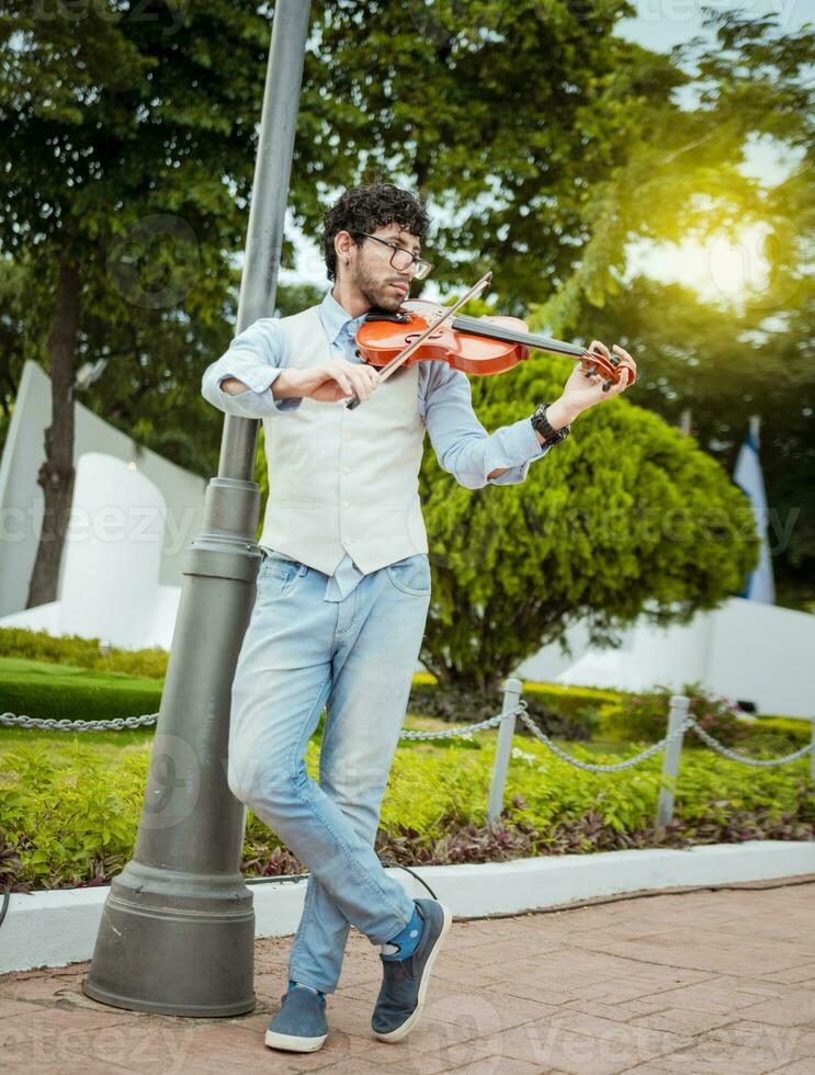 Mann spielen Violine im das Straße. Porträt von Mann spielen Violine im das Straße. Jacke Künstler spielen Violine draußen, Bild von ein Person spielen Violine draußen foto