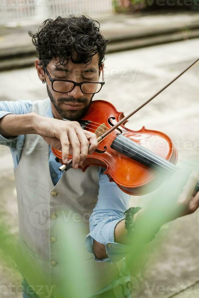 gut aussehend Mann im Weste spielen Violine draußen. schließen oben von Violinist Mann spielen ein Melodie draußen. Violinist Künstler spielen ein Melodie draußen. foto