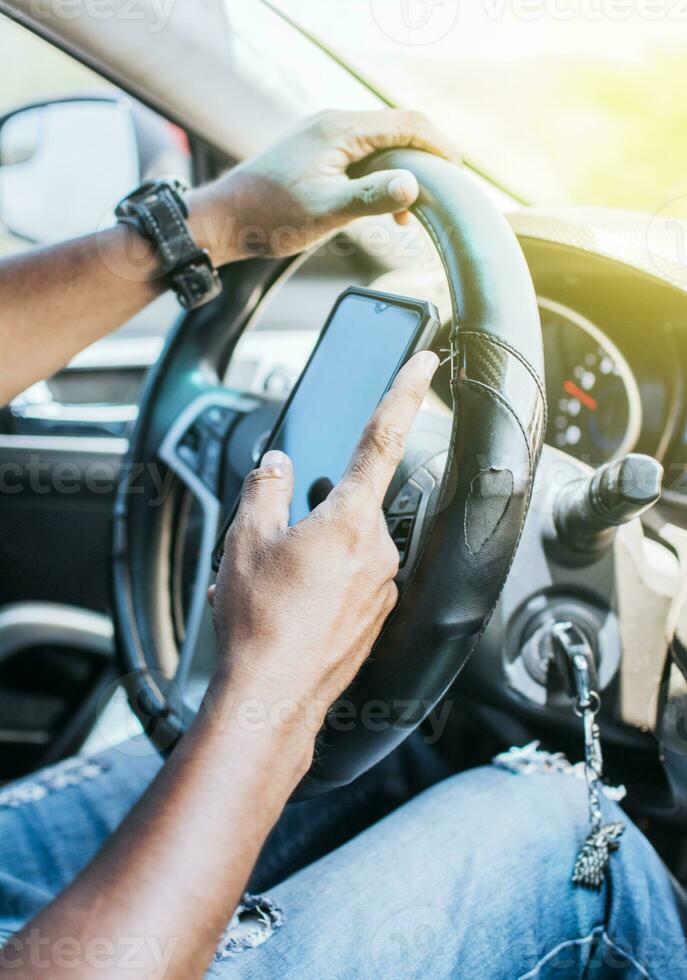 schließen oben von Treiber Hände mit seine Telefon, Konzept Treiber Hände berühren Zelle Telefon Bildschirm, Person im seine Auto mit Zelle Telefon foto