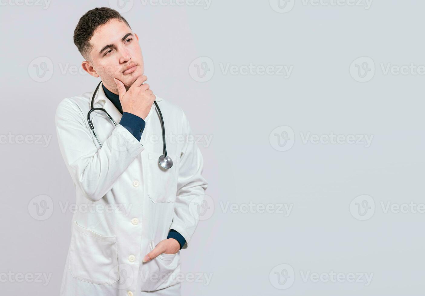 Arzt Denken mit Hand auf kinn. nachdenklich Arzt Mann suchen hoch, jung Arzt Denken und suchen oben isoliert foto