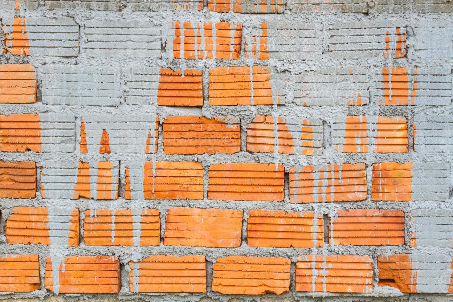 Nahaufnahme orange horizontal strukturierter Ziegel mit trockenem Betonfleck. foto