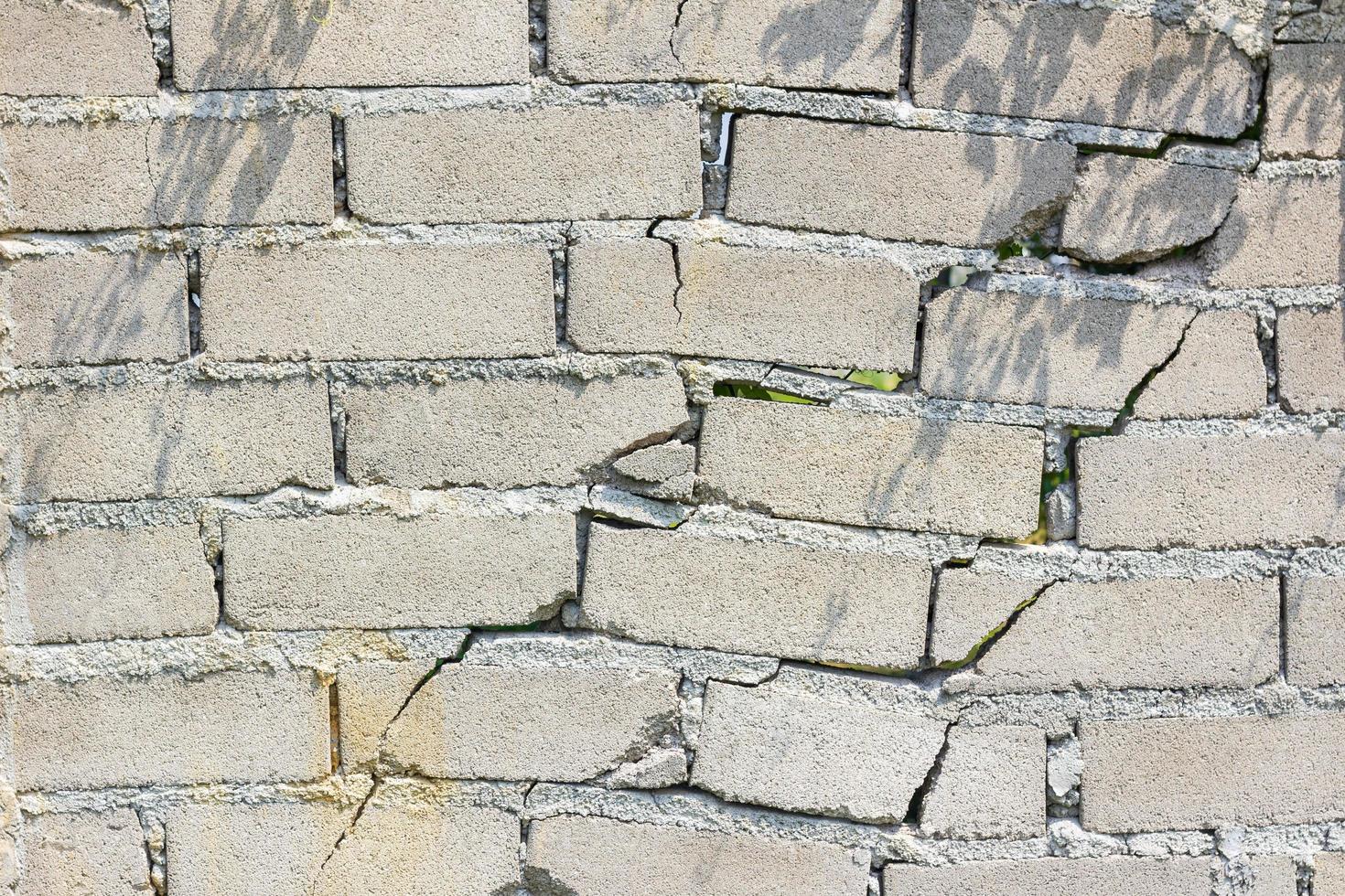 Nahaufnahme einer gefährlichen Wand mit Rissen in der Sonne foto