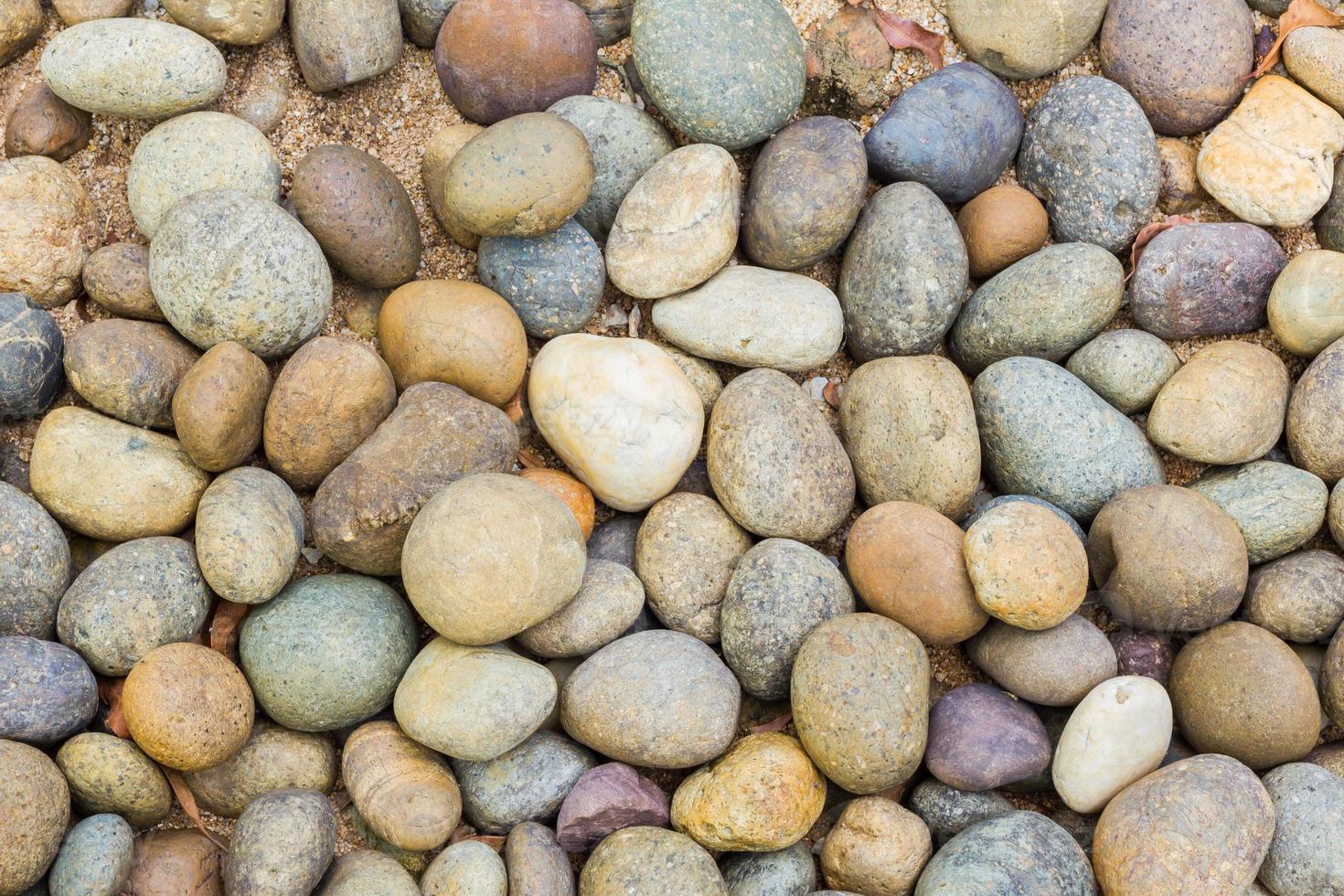 Kieselsteine in vielen Formen am Strand, abstrakter Hintergrund foto