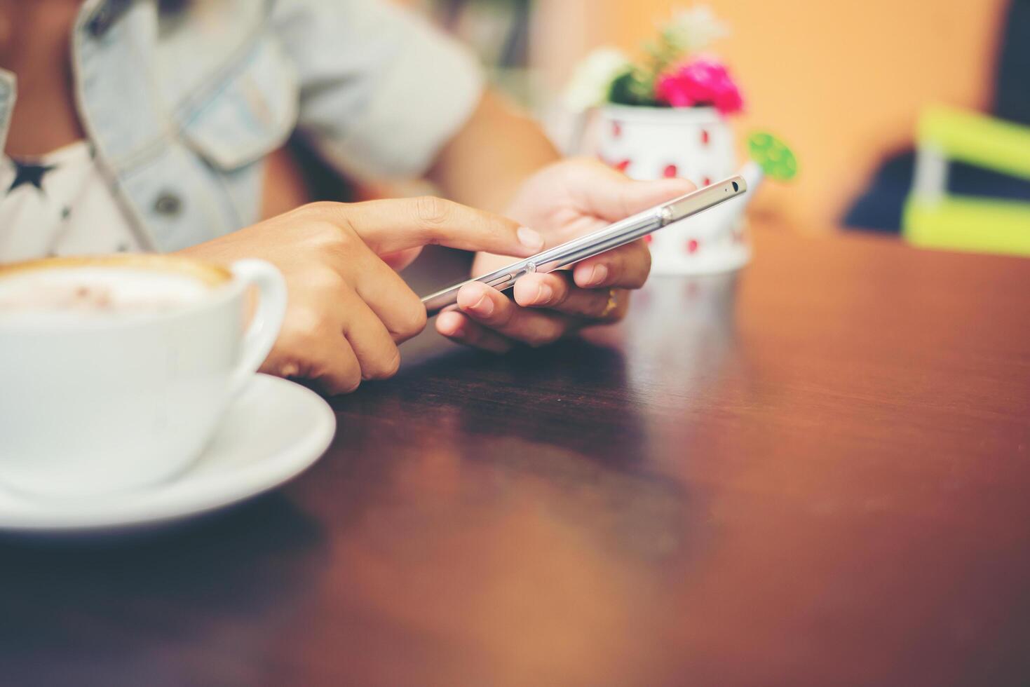 Nahaufnahme der Frau übergibt Textnachrichten mit ihrem Handy im Café. foto