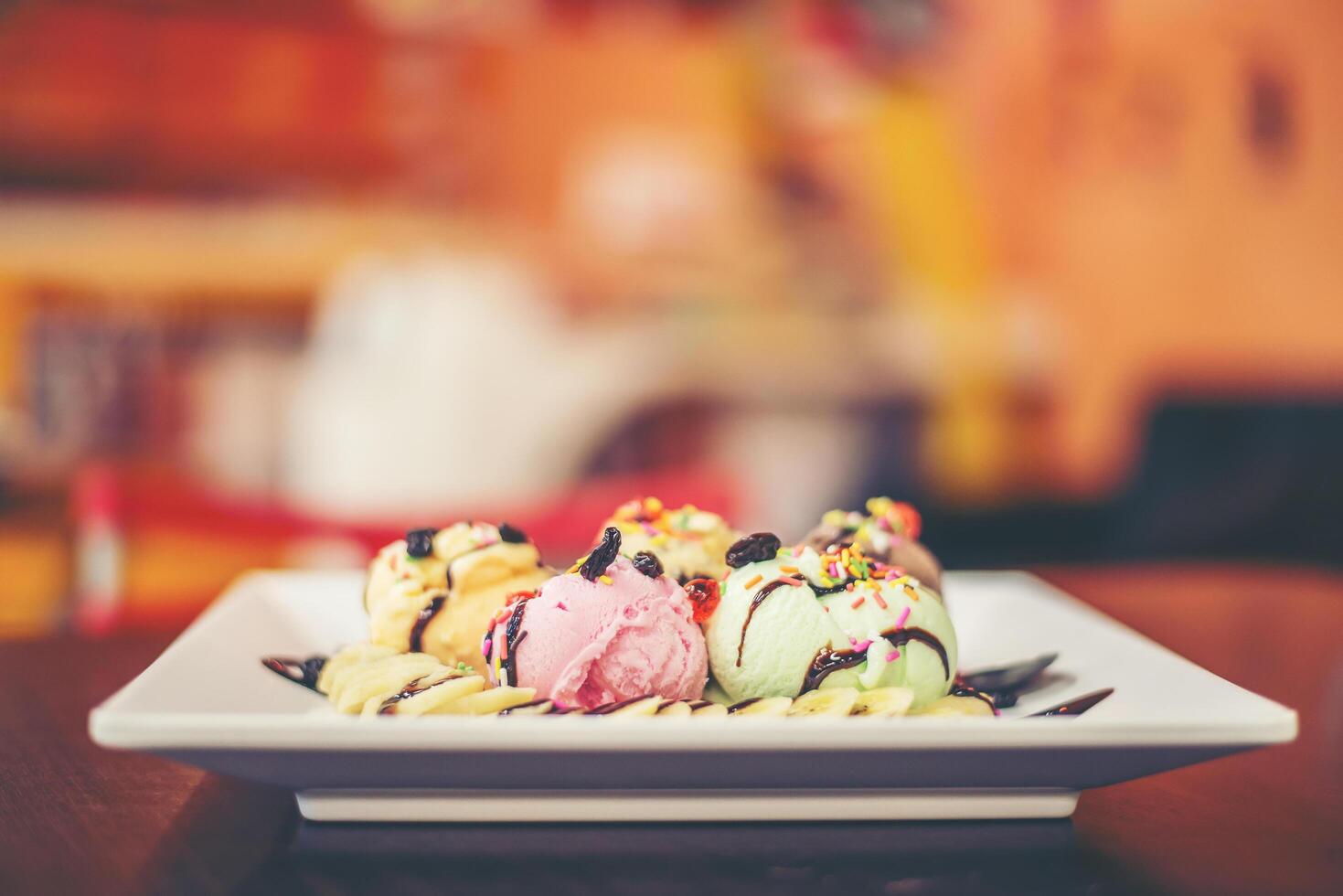 Eisbecher Vanille-Erdbeer-Schoko-Zitronen-Kugeln mit Banane foto