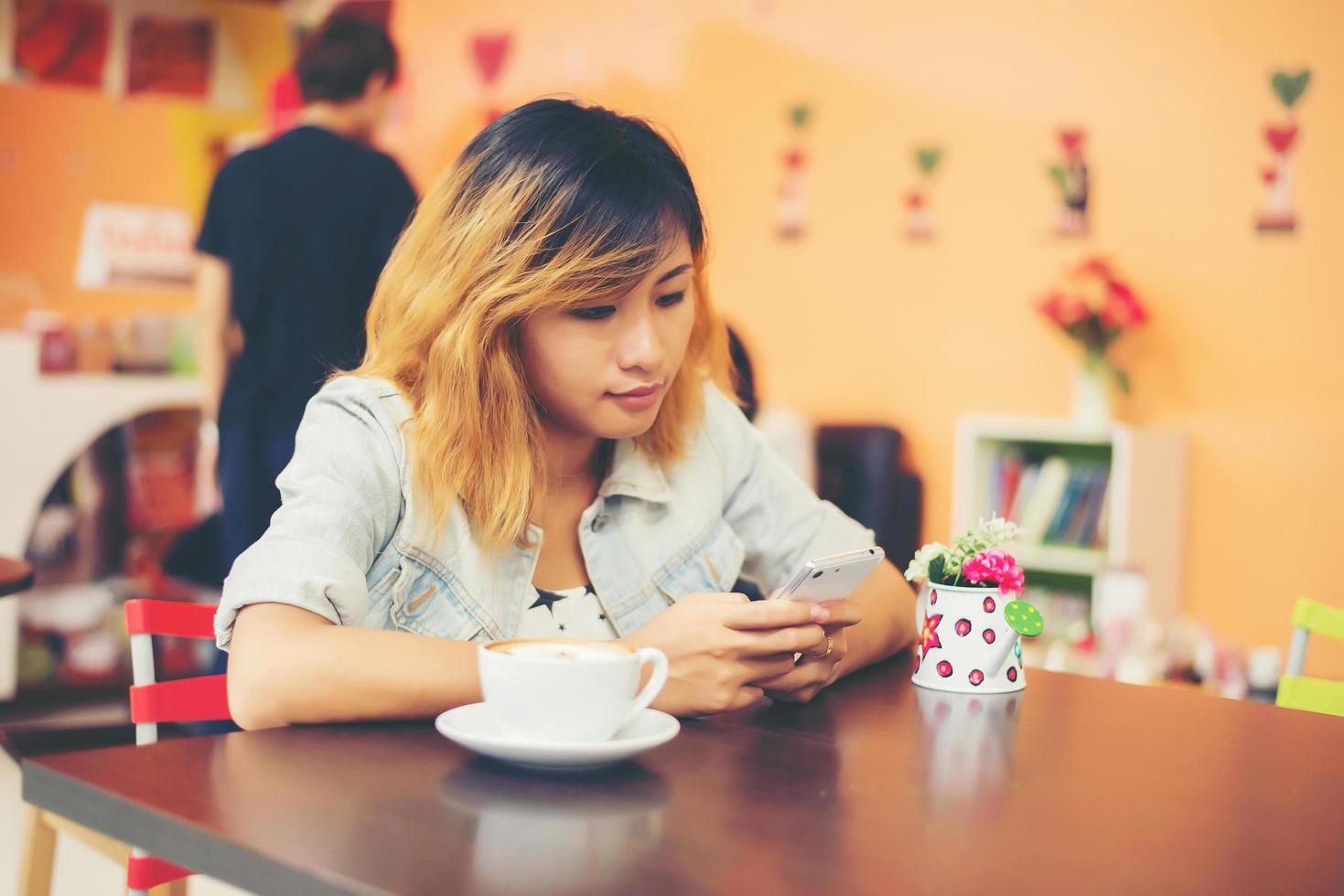 Nahaufnahme der Frau Textnachrichten mit ihrem Handy im Café. foto