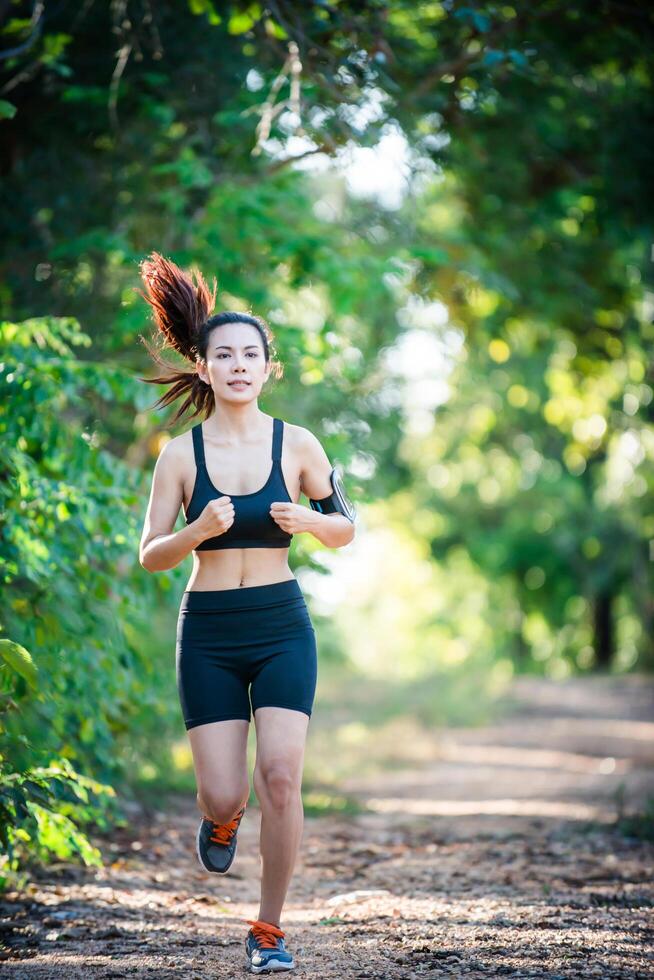 junge Fitness-Frau, die auf einer Landstraße läuft. Sportfrau läuft. foto