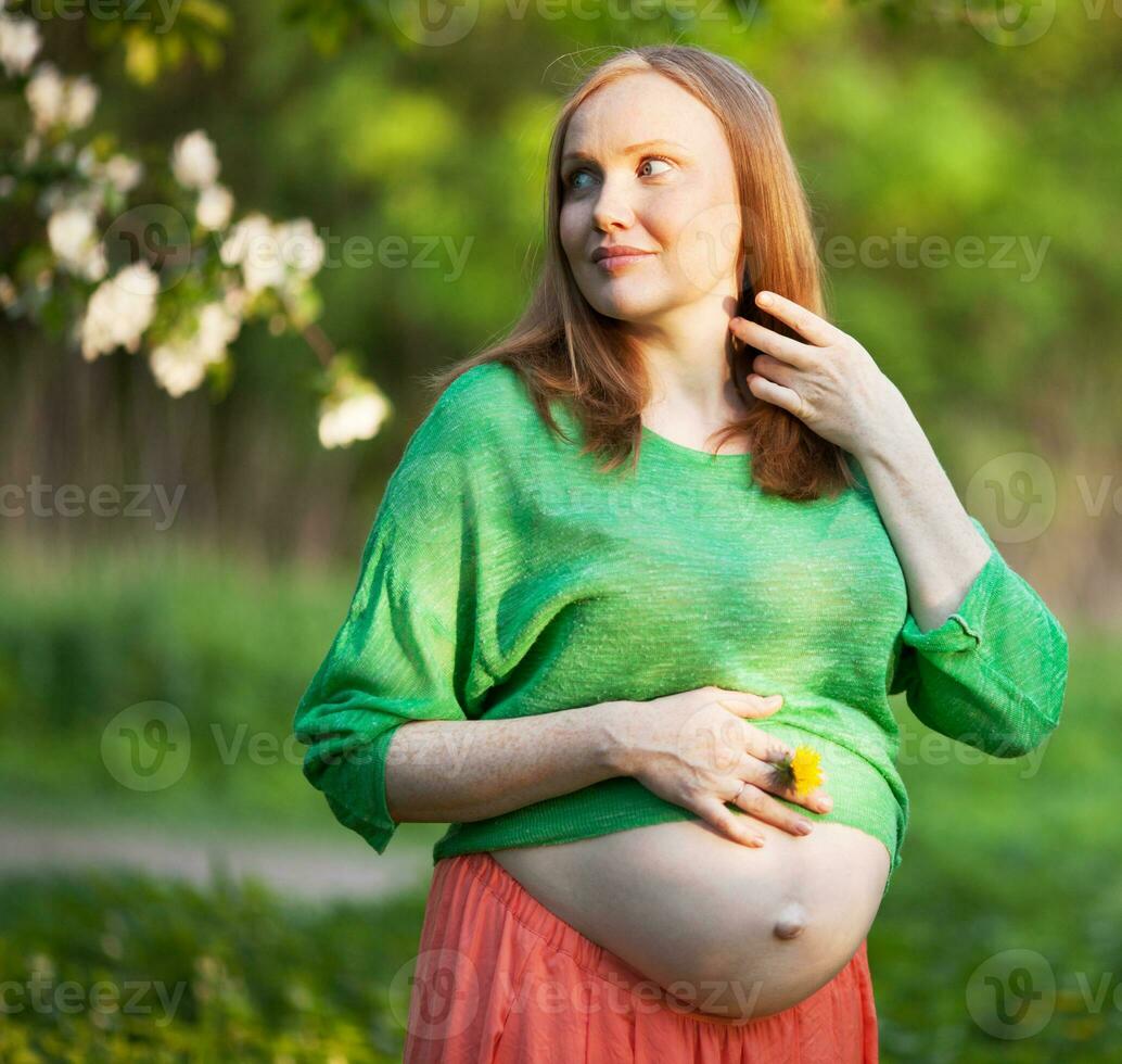 schwanger Frau im das Licht von Abend Sonne draussen foto