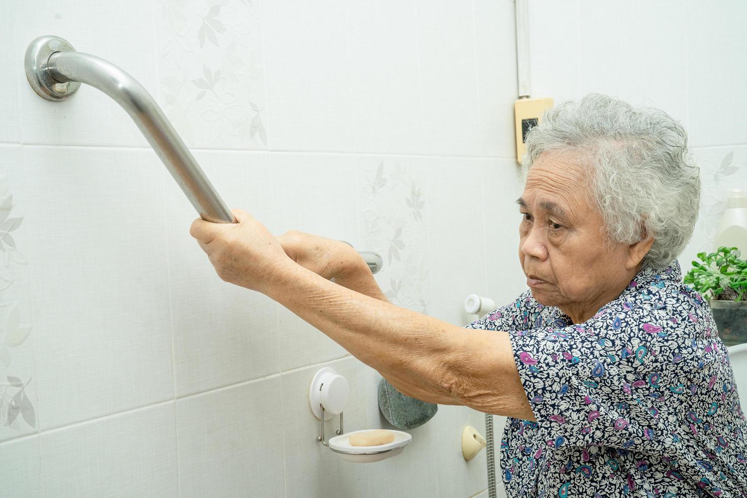 Asiatische Senioren oder ältere alte Damenpatienten verwenden Steigungsgehweg-Griffsicherheit mit Hilfe Unterstützungsassistent in Krankenstation gesundes starkes medizinisches Konzept. foto