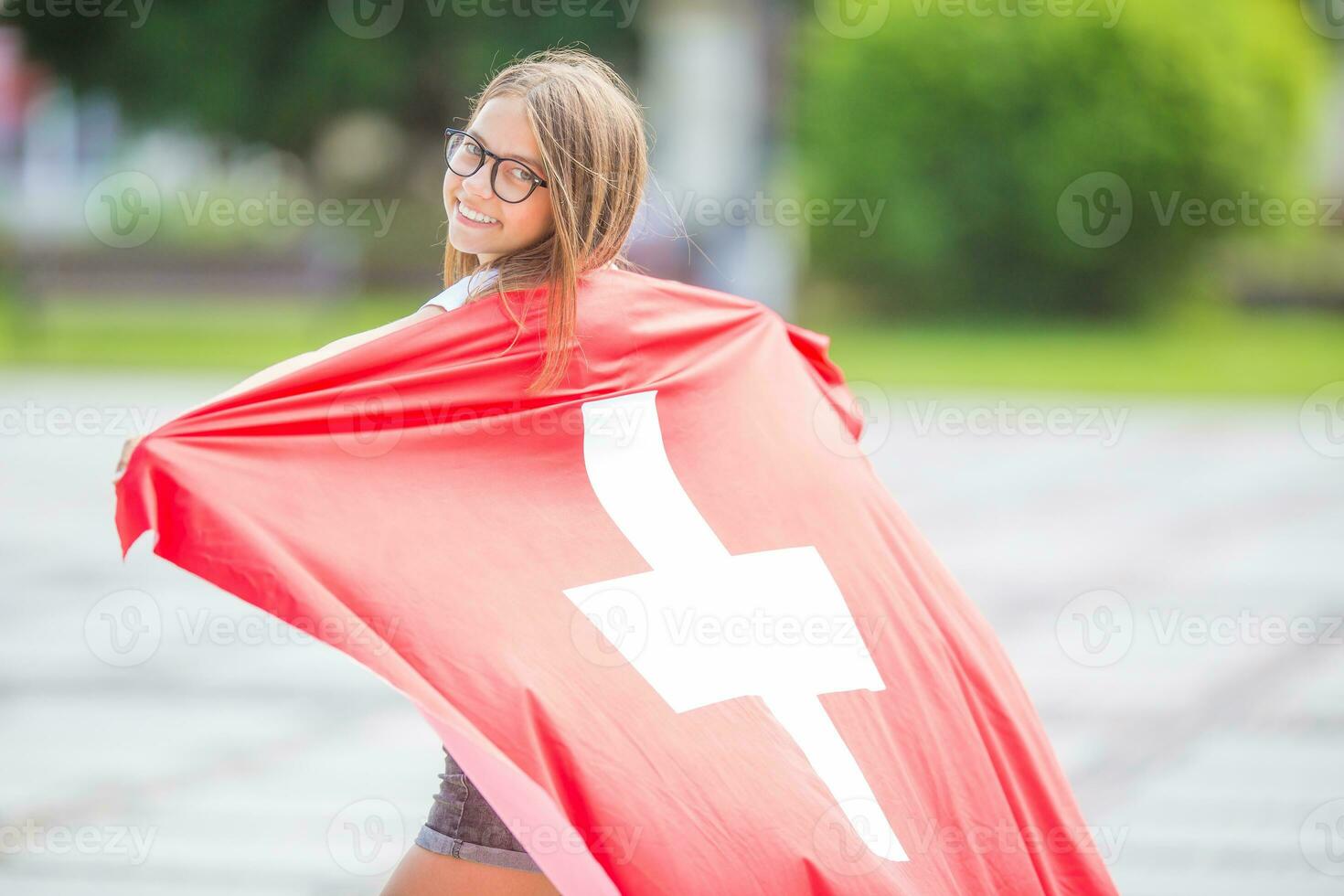 glücklich Mädchen Tourist Gehen im das Straße mit Schweiz Flagge foto