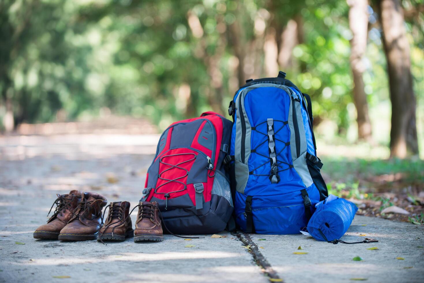 Rucksack und Schuhe Rucksacktouristen ruhen sich beim Wandern auf der Straße aus. foto