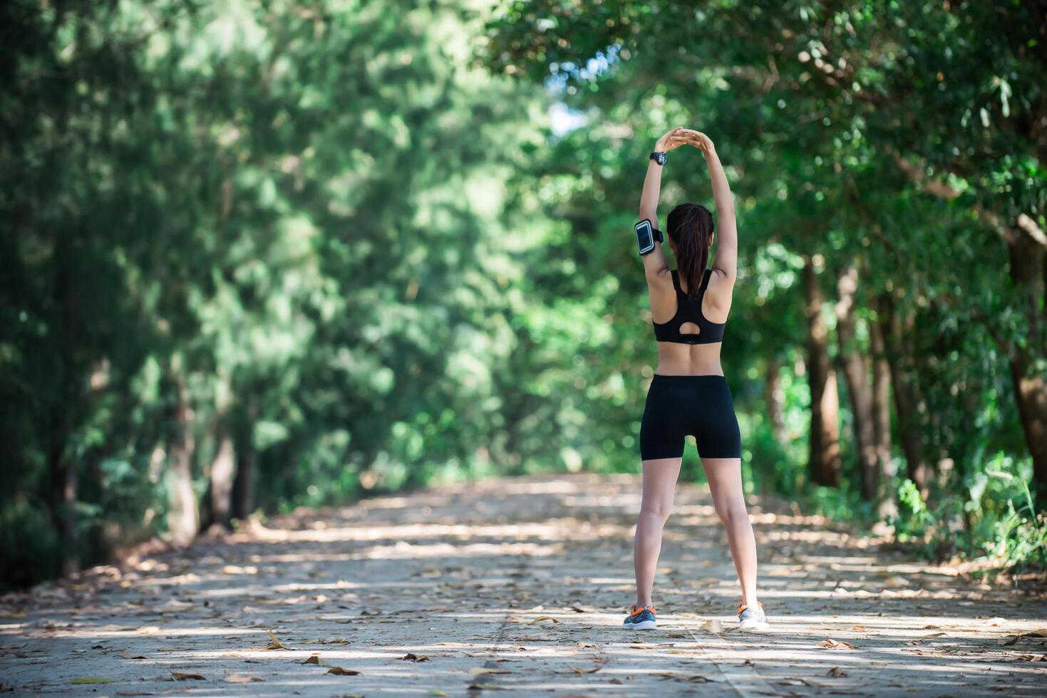 junge Fitnessfrau, die vor dem Lauf die Beine ausdehnt. foto