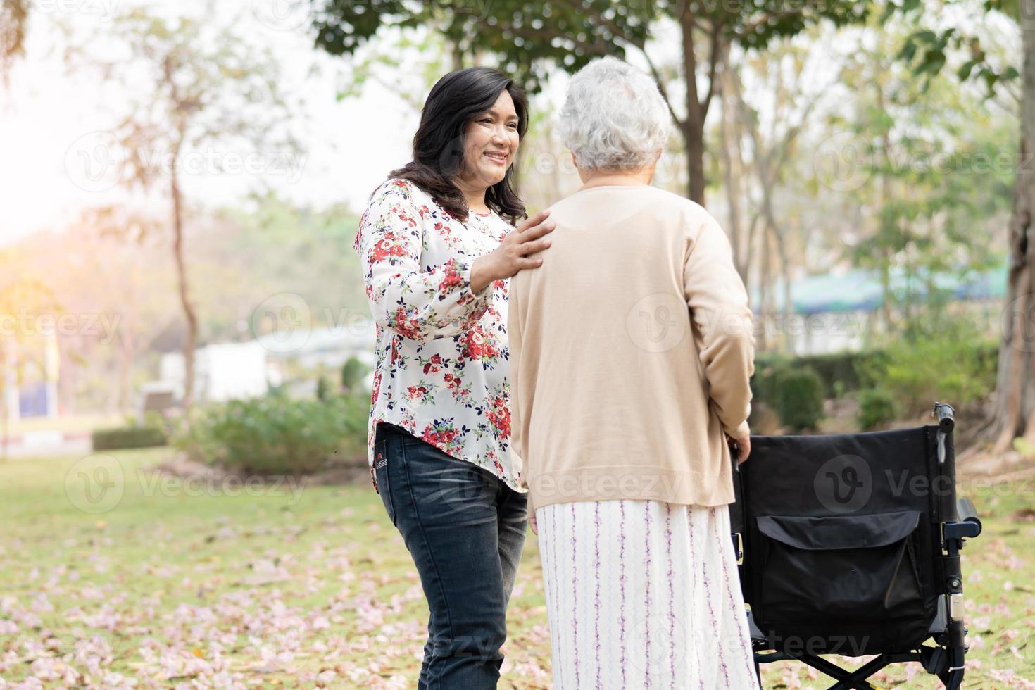 asiatische ältere Patientin mit Rollstuhl im Park foto