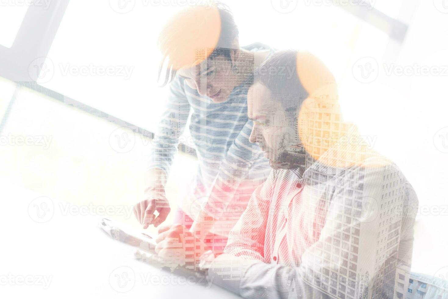Zwei Geschäftsleute, die mit einem Tablet im Startup-Büro arbeiten foto