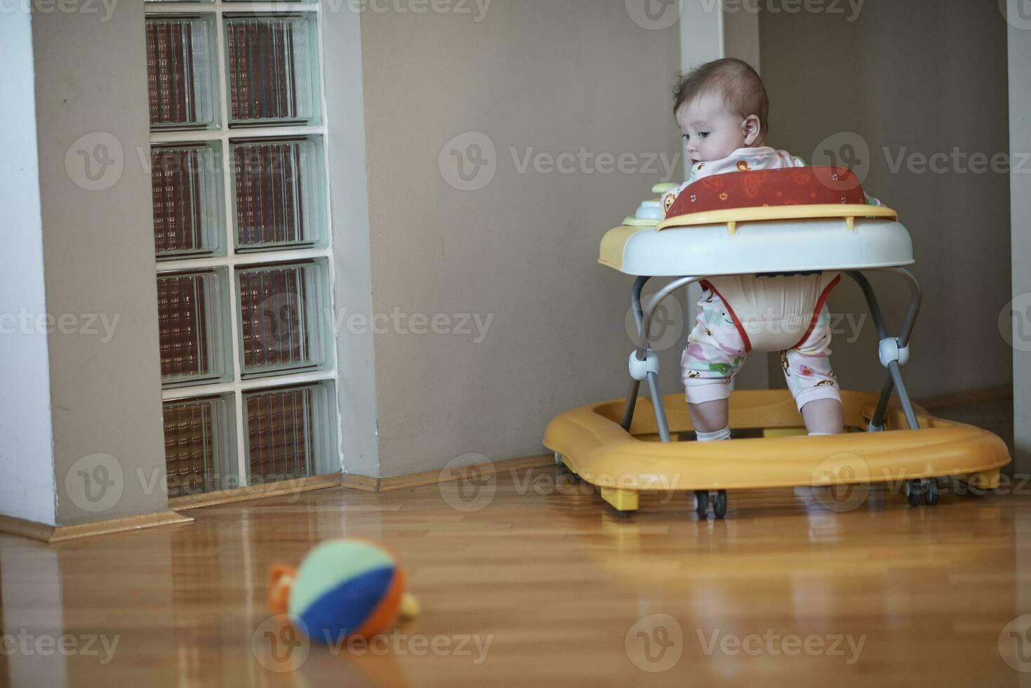 baby, das lernt, im gehwagen zu laufen foto