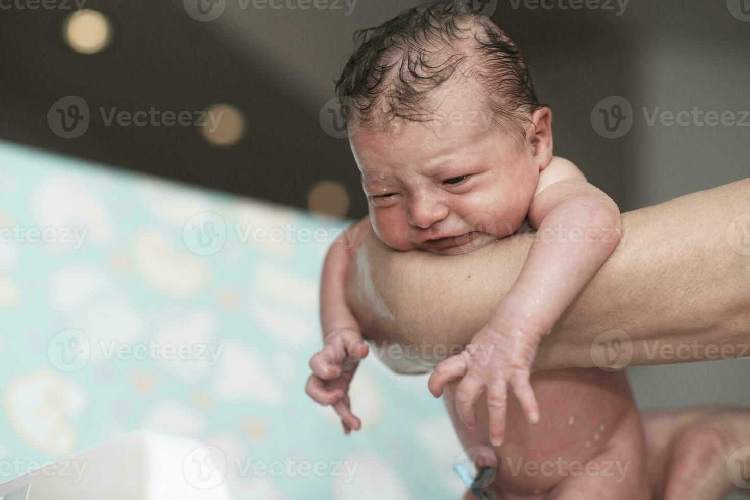 Neugeborenes Mädchen, das ein erstes Bad nimmt foto