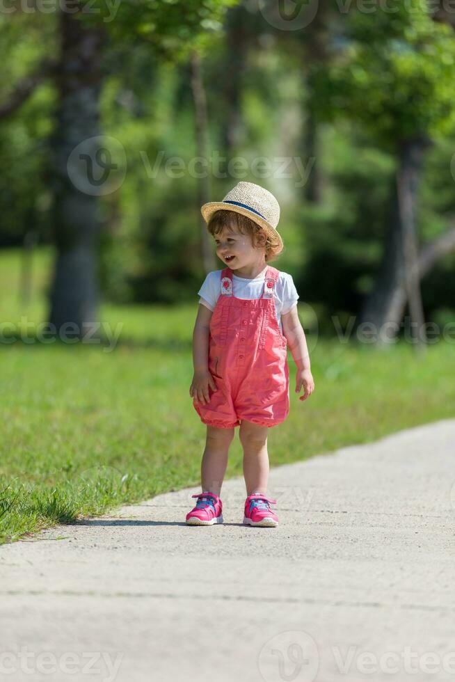 kleines Mädchen, das im Sommerpark läuft foto