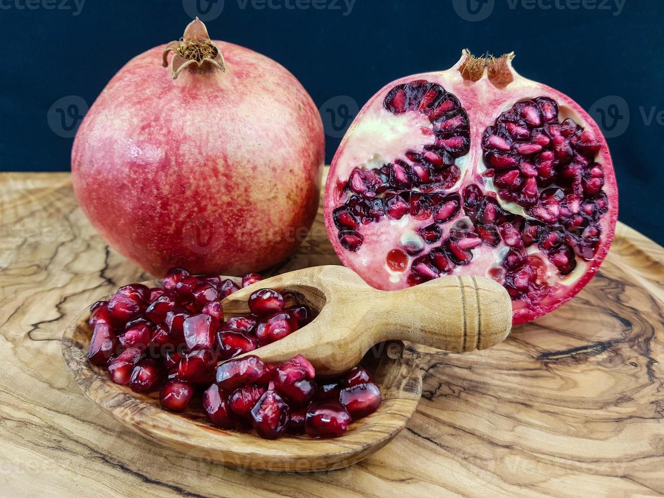 roter Granatapfel auf Olivenholz foto