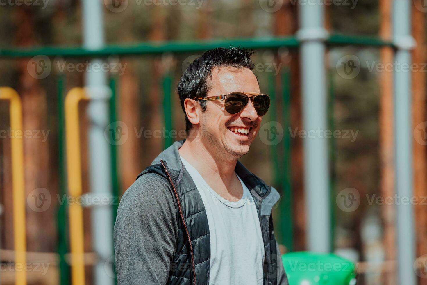 ein modern Mann mit Sonnenbrille Ausgaben ein sonnig Tag im das Park foto