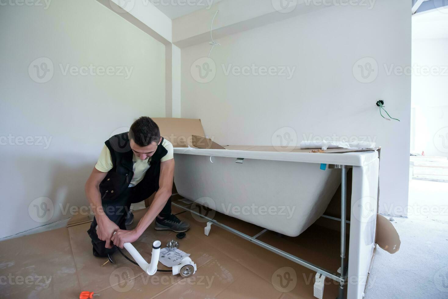 Professioneller Klempner, der in einem Badezimmer arbeitet foto