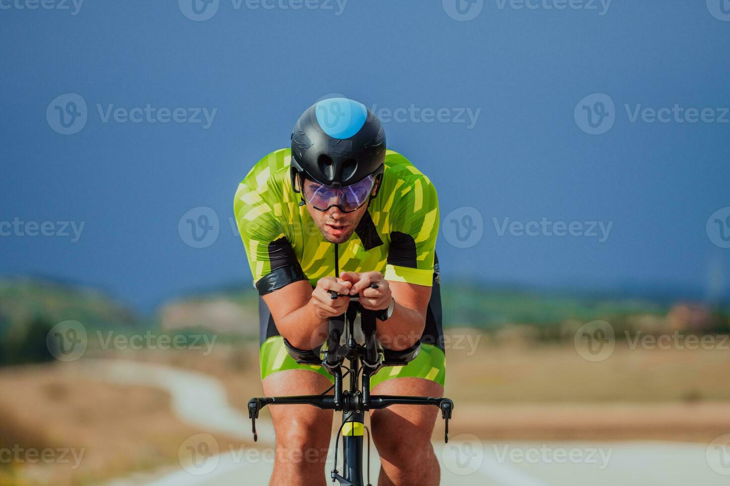 voll Länge Porträt von ein aktiv Triathlet im Sportbekleidung und mit ein schützend Helm Reiten ein Fahrrad. selektiv Fokus foto