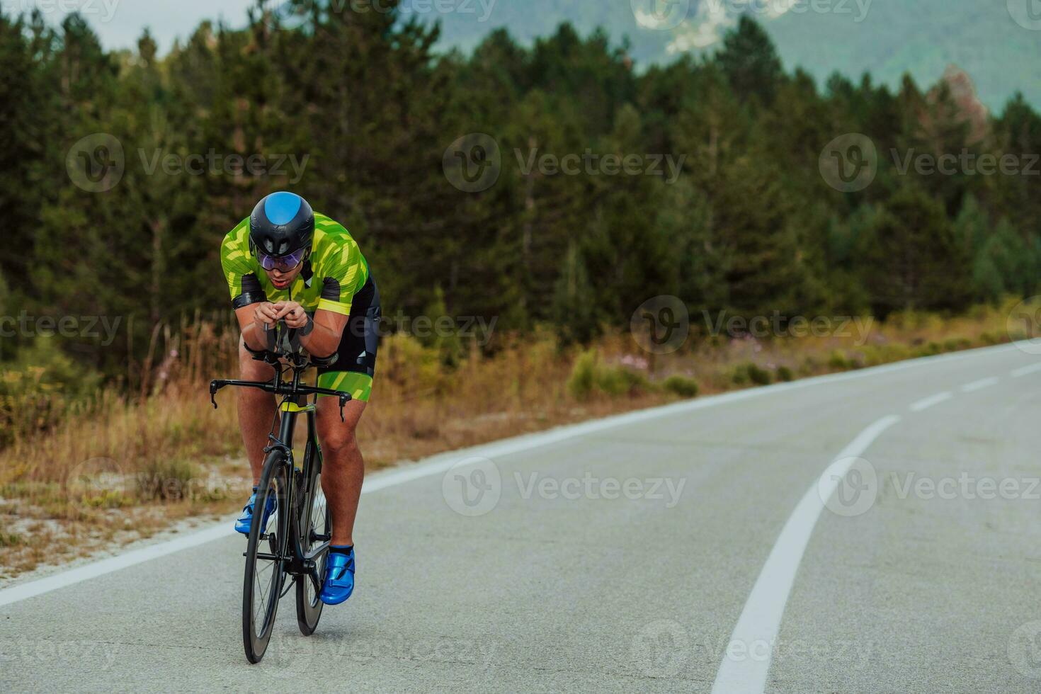 voll Länge Porträt von ein aktiv Triathlet im Sportbekleidung und mit ein schützend Helm Reiten ein Fahrrad. selektiv Fokus foto