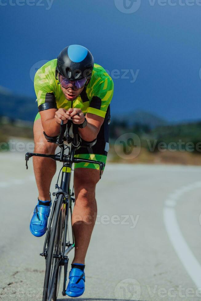 voll Länge Porträt von ein aktiv Triathlet im Sportbekleidung und mit ein schützend Helm Reiten ein Fahrrad. selektiv Fokus foto