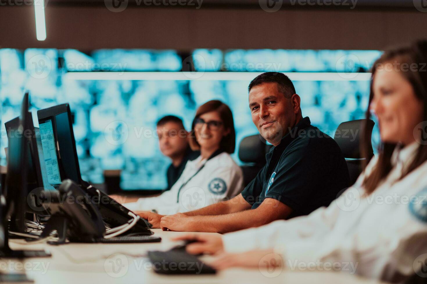 Gruppe von Sicherheit Daten Center Betreiber Arbeiten im ein cctv Überwachung Zimmer suchen auf mehrere Monitore Offiziere Überwachung mehrere Bildschirme zum verdächtig Aktivitäten Mannschaft Arbeiten auf das System kontr foto