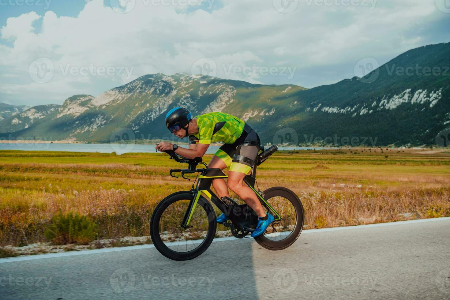 voll Länge Porträt von ein aktiv Triathlet im Sportbekleidung und mit ein schützend Helm Reiten ein Fahrrad. selektiv Fokus foto