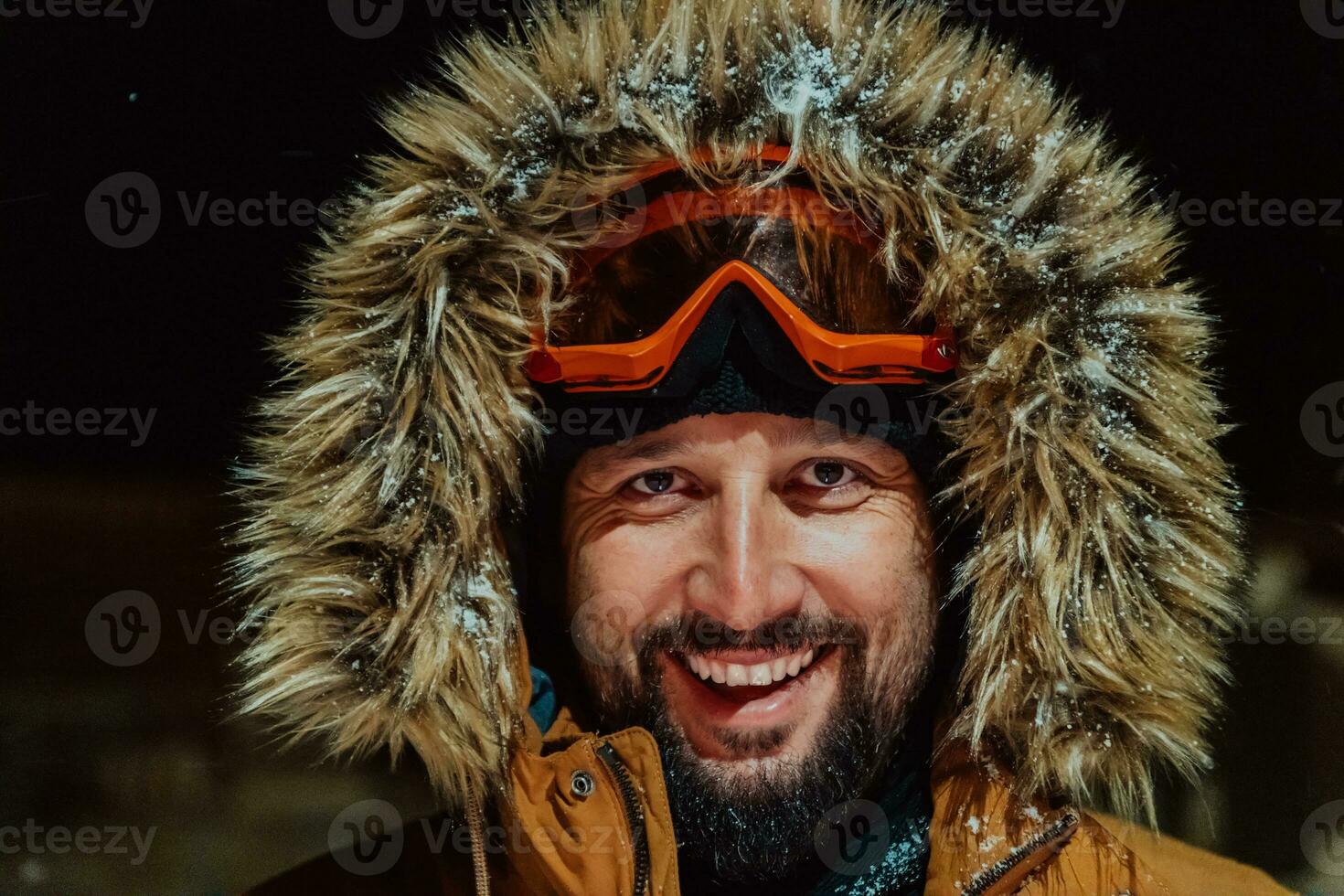 Kopf Schuss von ein Mann im ein kalt schneebedeckt Bereich tragen ein dick braun Winter Jacke, Schnee Brille und Handschuhe auf ein kalt skandinavisch Nacht. Leben im das kalt Regionen von das Land. foto