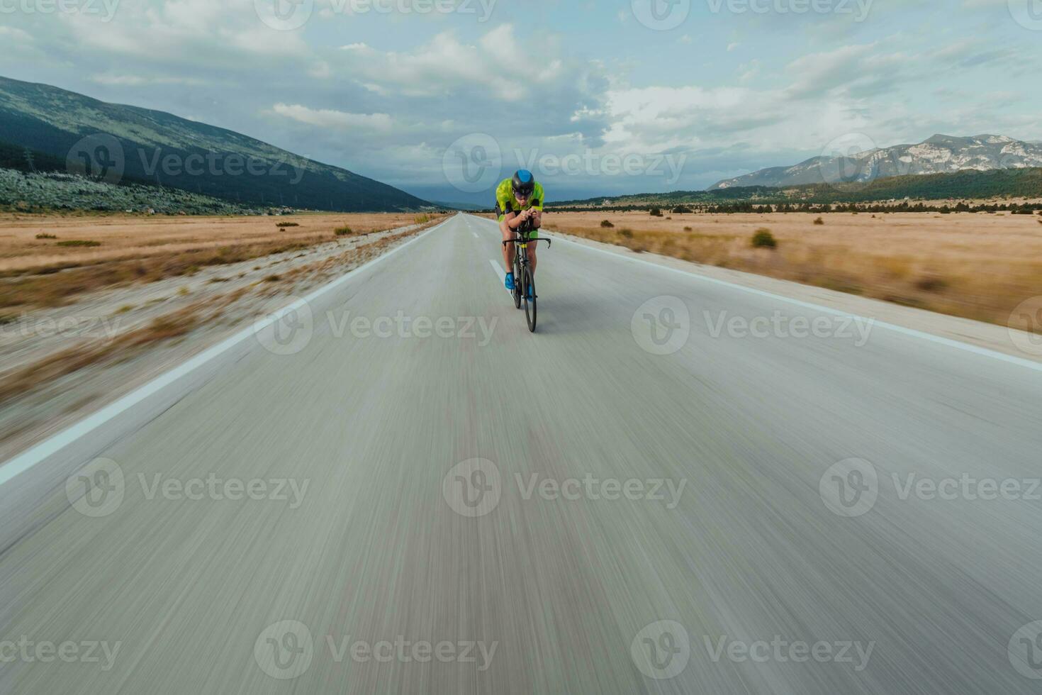 voll Länge Porträt von ein aktiv Triathlet im Sportbekleidung und mit ein schützend Helm Reiten ein Fahrrad. selektiv Fokus foto