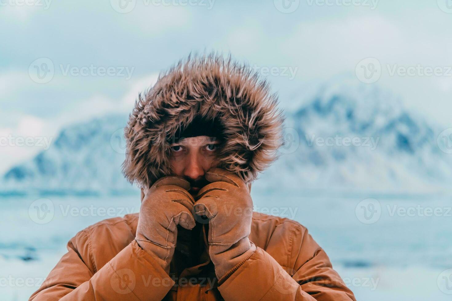 Kopfschuss Foto von ein Mann im ein kalt schneebedeckt Bereich tragen ein dick braun Winter Jacke und Handschuhe. Leben im kalt Regionen von das Land.