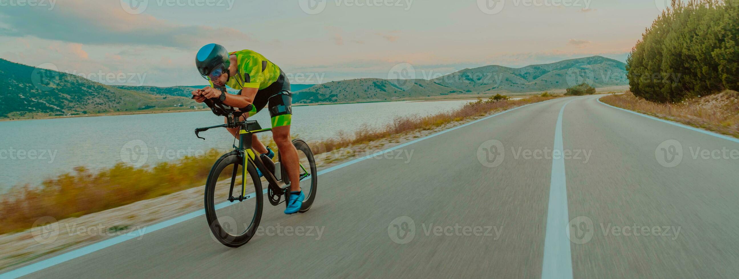 voll Länge Porträt von ein aktiv Triathlet im Sportbekleidung und mit ein schützend Helm Reiten ein Fahrrad. selektiv Fokus foto