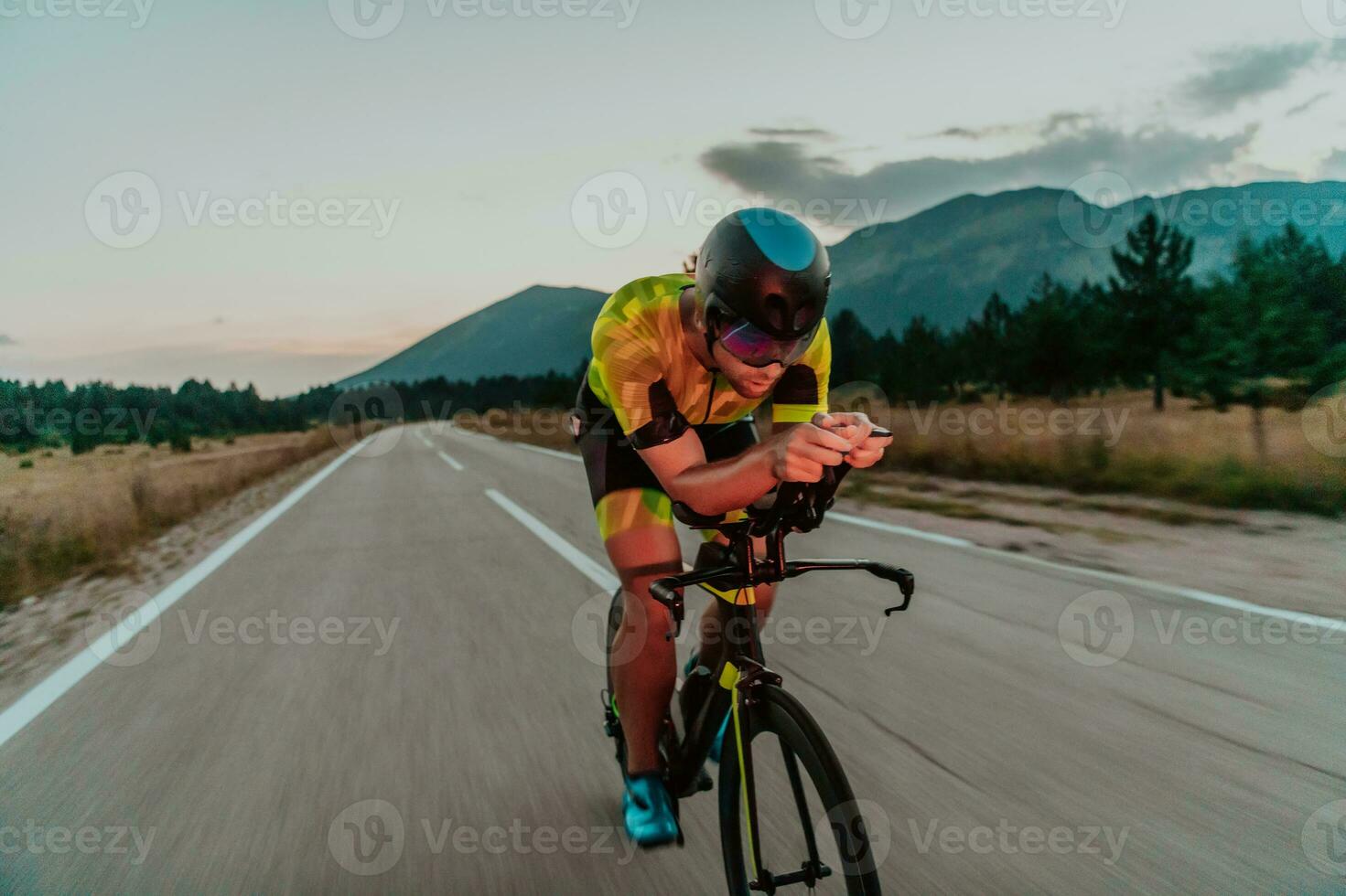 Nacht Antrieb. voll Länge Porträt von ein aktiv Triathlet im Sportbekleidung und mit ein schützend Helm Reiten ein Fahrrad im Nacht Zeit.. selektiv Fokus foto