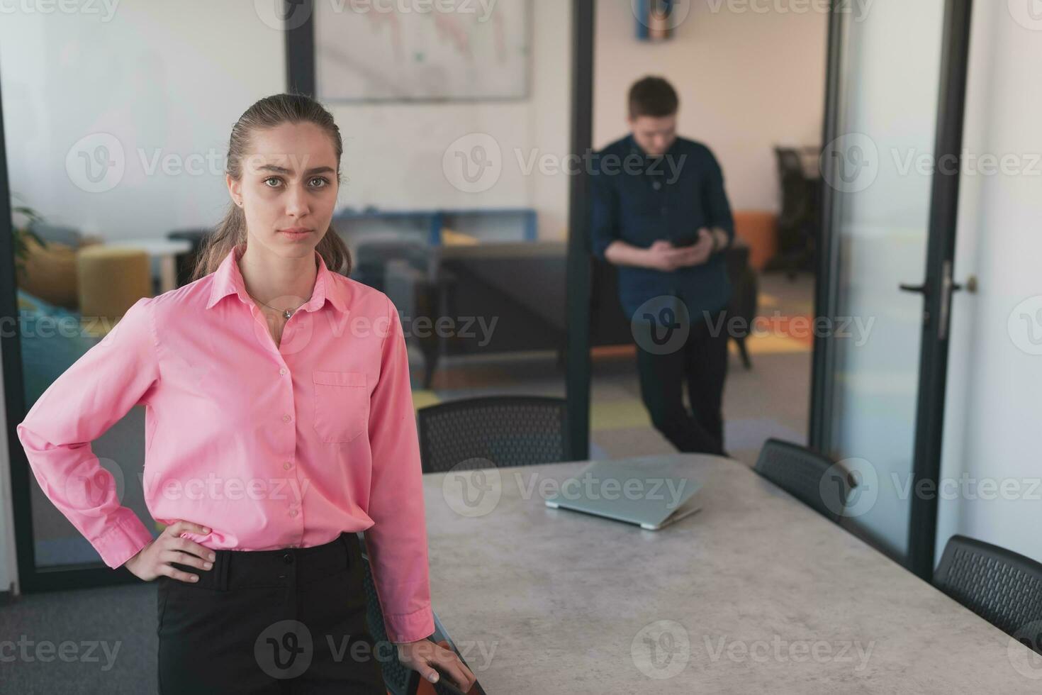 Porträt von jung lächelnd Geschäft Frau im kreativ öffnen Raum Coworking Anfang Büro. erfolgreich Geschäftsfrau Stehen im Büro mit Exemplar. Mitarbeiter Arbeiten im Hintergrund. foto