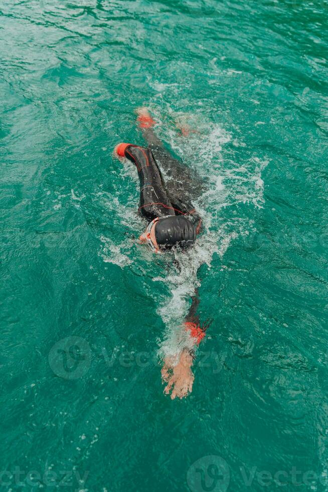 ein Triathlet im ein Fachmann Schwimmen passen Züge auf das Fluss während vorbereiten zum olympisch Schwimmen foto