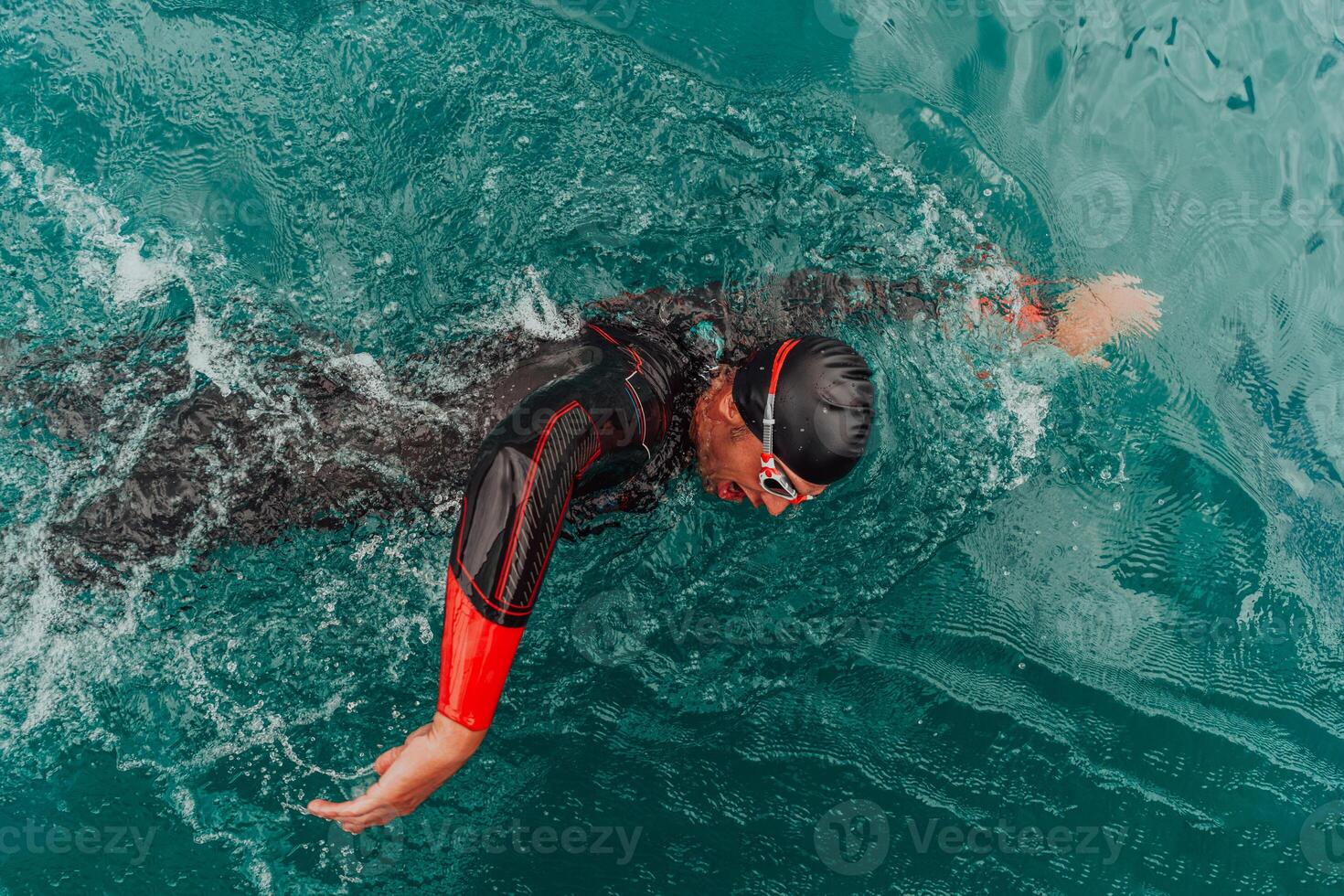 ein Triathlet im ein Fachmann Schwimmen passen Züge auf das Fluss während vorbereiten zum olympisch Schwimmen foto