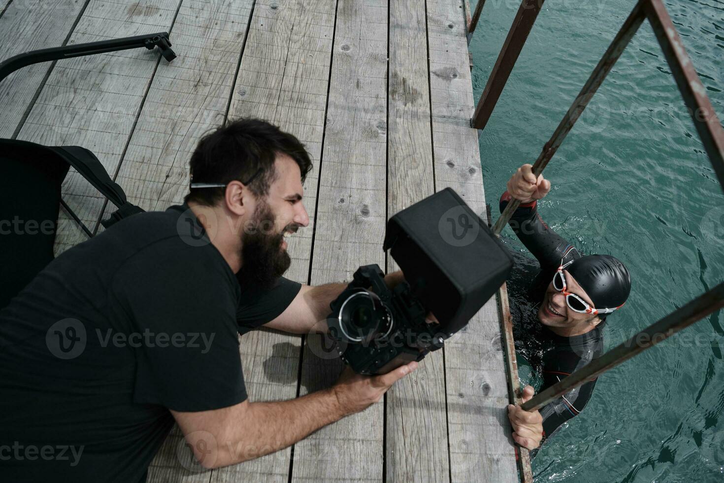 Videofilmer, der einen Triathlon-Schwimmsportler fotografiert foto