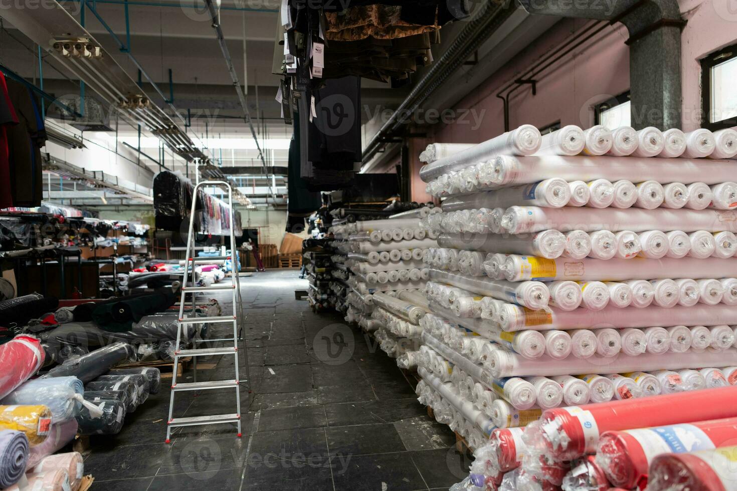 Innere von ein industriell Warenhaus mit Stoff Rollen Proben. klein Geschäft Textil- bunt Lagerhaus. foto