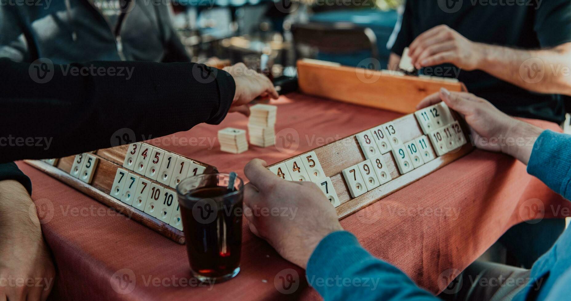 ein Gruppe von Männer trinken traditionell Türkisch Tee und abspielen ein Türkisch Spiel namens okey foto