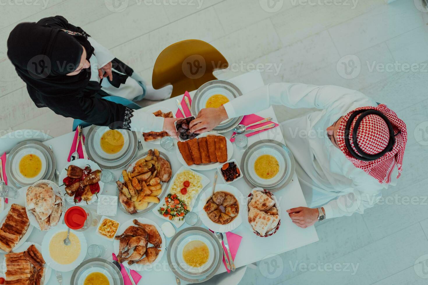 oben Aussicht von Muslim Familie haben iftar Abendessen Trinken Wasser zu brechen Fest. Essen traditionell Essen während Ramadan schlemmen Monat beim heim. das islamisch halal Essen und Trinken im modern Zuhause foto