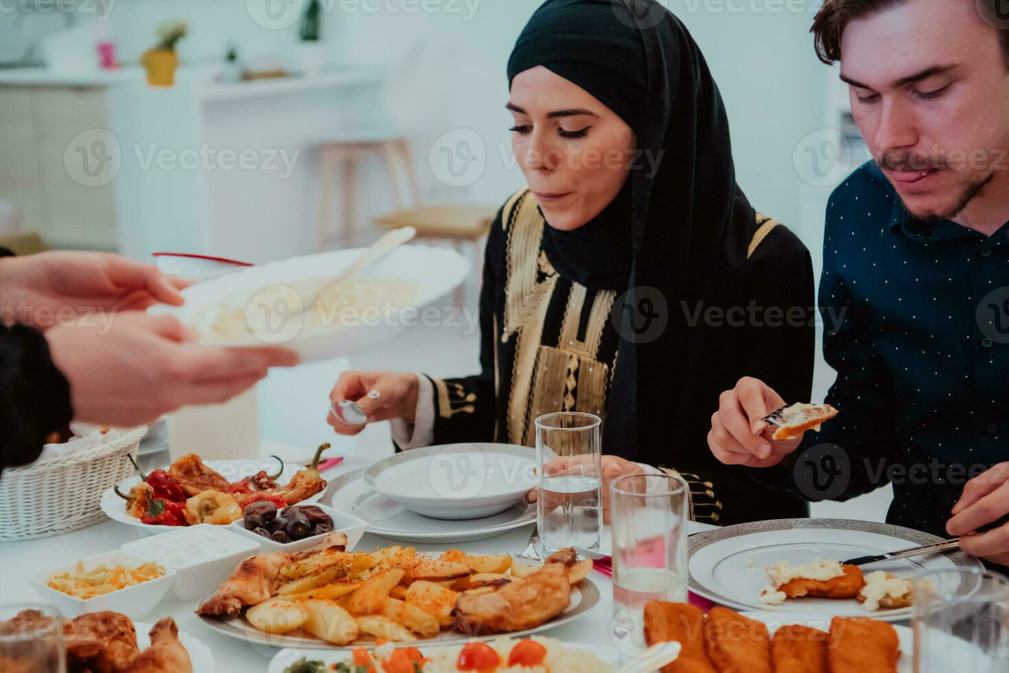 Muslim Familie haben iftar Abendessen Trinken Wasser zu brechen Fest. Essen traditionell Essen während Ramadan schlemmen Monat beim heim. das islamisch halal Essen und Trinken im modern Zuhause foto