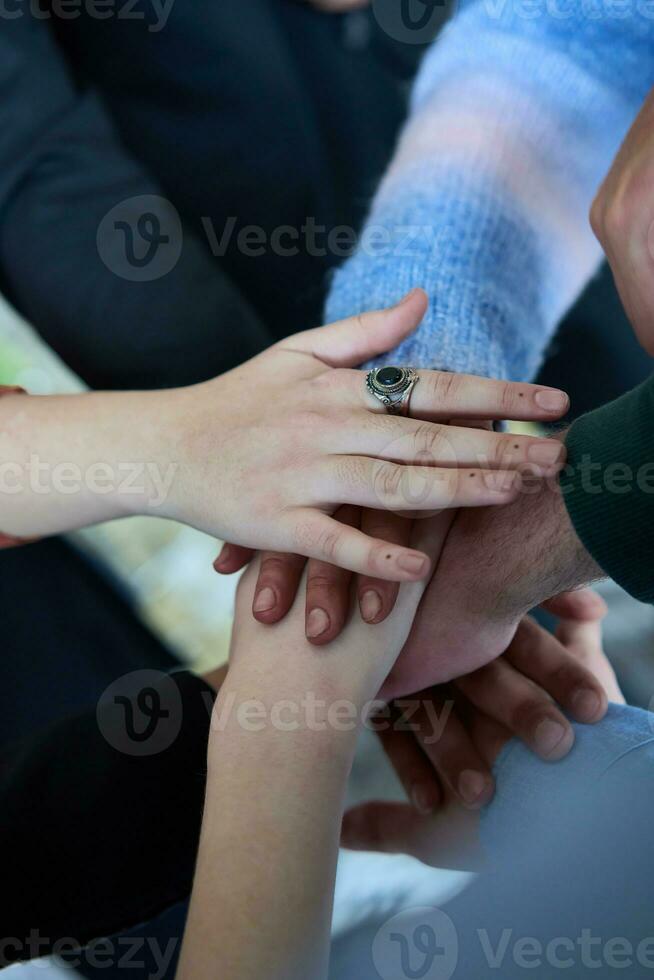 ein oben Aussicht Foto von Gruppe von Geschäftsleute halten Hände zusammen zu symbolisieren Einheit und Stärke