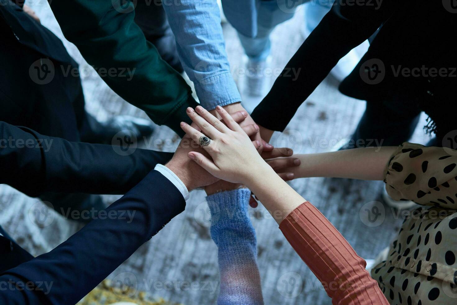 ein oben Aussicht Foto von Gruppe von Geschäftsleute halten Hände zusammen zu symbolisieren Einheit und Stärke